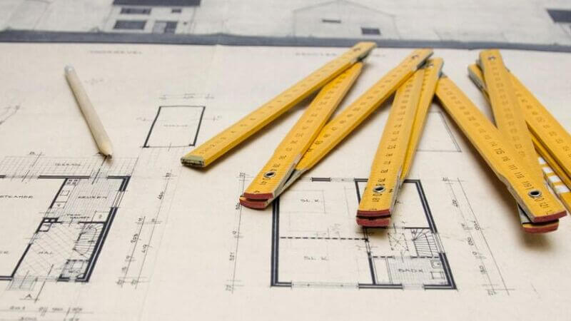 Régua e lápis acima de projeto de obras