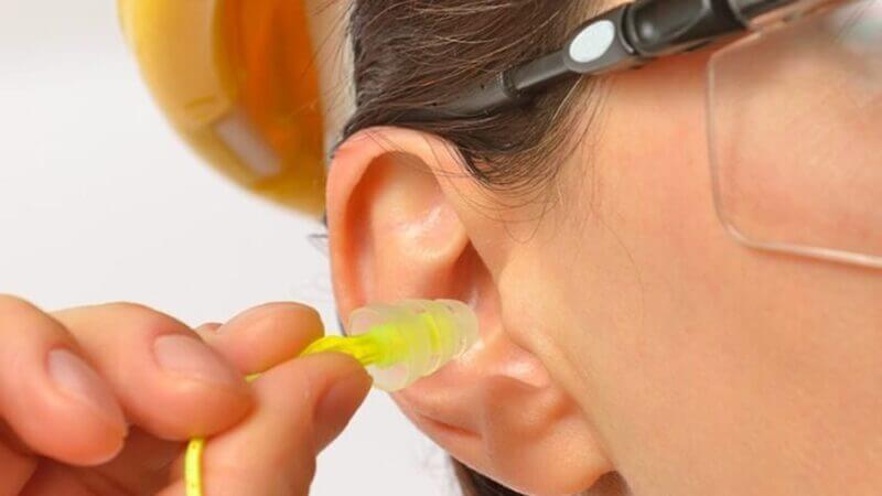 Protetor auditivo sendo colocado na orelha